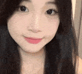 a close up of a woman 's face with long black hair and pink lipstick .