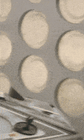 a blurred image of a person standing in front of a wall of circles
