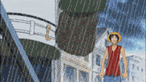 a man in a red shirt and straw hat stands in the rain with a belt that has the letter e on it