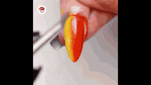 a close up of a person 's nails being painted with a brush .