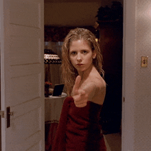 a woman wrapped in a red towel is pointing her finger