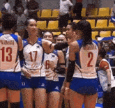 a group of female volleyball players one of whom has the number 17 on her jersey