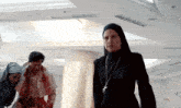a woman in a nun 's hood is standing in a hallway with blood on her face
