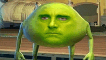 a green monster with a man 's face on it is standing in a room .