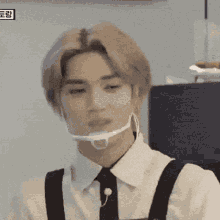 a man wearing a white shirt and black suspenders has a mask on his face