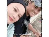 a man and a woman are posing for a picture and the caption says " selamat aikum "