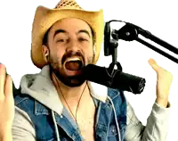 a man wearing a cowboy hat and a denim jacket singing into a microphone