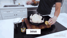 a man is squeezing a lemon over a chicken