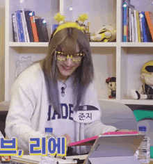 a woman wearing glasses and a name tag that says jade is sitting in front of a bookshelf