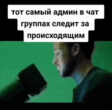 a man is holding a cup in front of a green background with russian writing