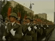a group of soldiers marching down a street with a building in the background that says ' do '
