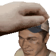 a man wearing a baseball cap is being patted on the forehead by a hand .