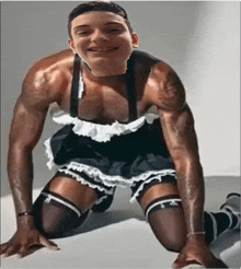 a man in a maid costume is kneeling down and smiling