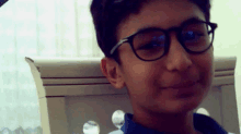 a young boy wearing glasses and a blue shirt