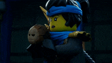 a lego figure with a blue scarf around her neck holds a sword