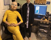 a boy in a mickey mouse costume is sitting in a chair next to another boy in a yellow costume .