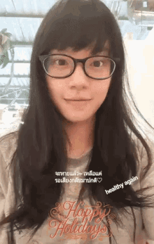 a woman wearing glasses and a shirt that says happy holidays on it