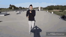 a man in a black sweater is standing in a skate park