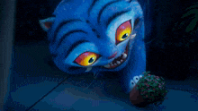 a close up of a blue cat 's face with yellow eyes and flowers in its mouth .