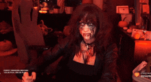 a woman with a mask on her face is sitting in front of a table with pumpkins