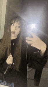 a girl taking a selfie in front of a mirror