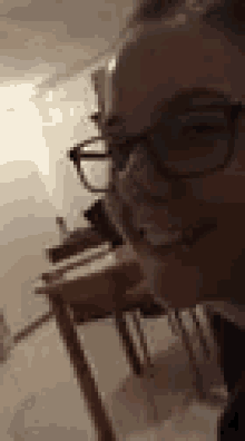 a woman wearing glasses is smiling and looking at the camera .