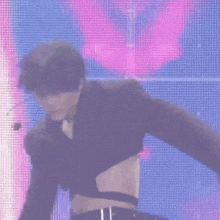 a woman in a black crop top is dancing on stage
