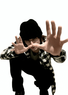 a person wearing a black hat and a plaid shirt is making a stop sign