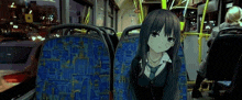 a girl is sitting on the back of a bus with a picture of her on the seat .