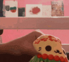 a person is holding a stuffed animal in front of a shelf with cards .