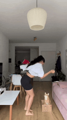 a woman playing with a cat in a cardboard box with the letter o on it