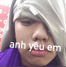 a person with a hood on their head and the words anh yêu em written on their face