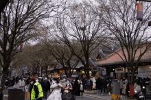 a group of people wearing face masks are walking down a street in front of a sign that says ' korean ' on it