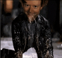 a man in a black shirt is covered in icing