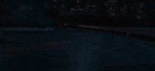a car is driving down a highway at night with a city in the background