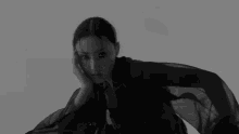 a black and white photo of a woman wearing a black dress