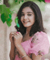 a woman in a pink dress is smiling and holding a pink flower