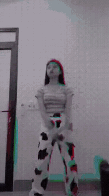a woman wearing cow print pants is standing in front of a white wall