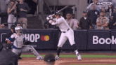 a baseball player is swinging at a pitch in front of a wall that says hop and book