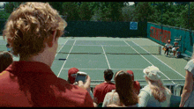 a group of people watching a tennis match with a banner that says stanford