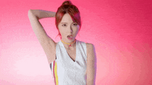 a woman with red hair is wearing a white tank top