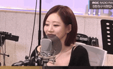 a woman is sitting in front of a microphone with a sign that says mbc radio fm on it