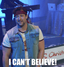 a man wearing a headband and a denim vest says i can 't believe