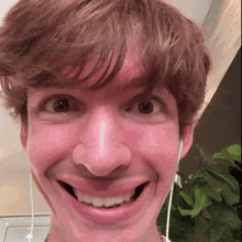 a close up of a man 's face with headphones on making a funny face