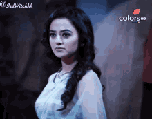 a woman is standing in front of a wall that says colors on it