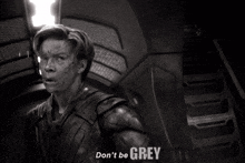 a black and white photo of a man with the words " don 't be grey " on the bottom