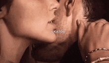 a woman is touching a man 's face with her hand .