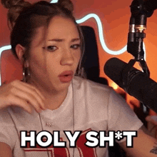 a woman sitting in front of a microphone says holy shit
