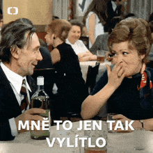 a man and a woman are sitting at a table with a bottle of wine and the words mne to jen tak vyliito