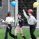 three girls are playing with balloons and one of them has a sweater that says ' aoa ' on it